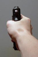 A pistol held upright in the proper technique.