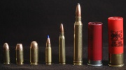 Photo of various cartridges, showing from left to right: 9x19mm Parabellum, .40 S&W, .45 ACP, 5.7x28mm, 5.56x45mm NATO, .300 Winchester Magnum, 2.75-inch 12 gauge, and 3-inch 12 gauge